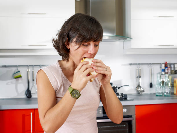 istock Woman in kitchen eating sandwiches 1341387037