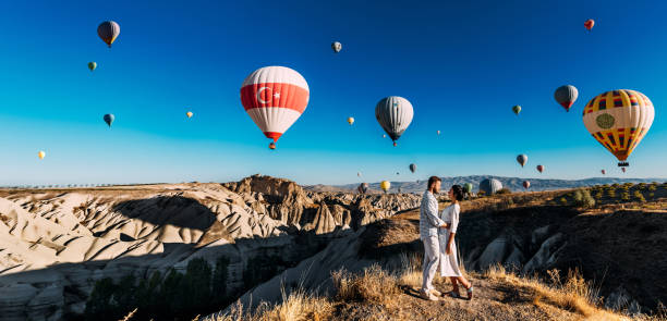 Turkey Cappadocia balloon flight, panorama. A beautiful couple on the background of balloons in Cappadocia. Travel to Turkey. Tourist places in Turkey. A wedding trip. Vacation in Turkey. Copy space stock photo