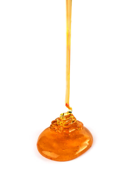 istock Pouring honey isolated on white background. 1341388220