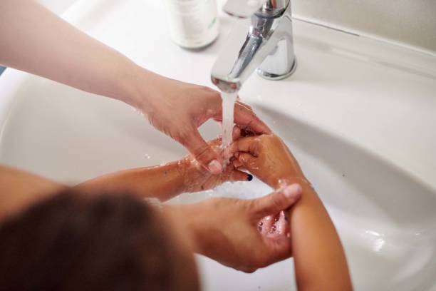 foto recortada de una mujer irreconocible ayudando a su hija a lavarse las manos en casa - mid adult women human skin neat good condition fotografías e imágenes de stock