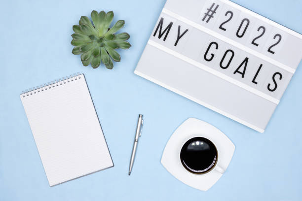istock Open blank notebook page, pen, coffee cup, lightbox with My Goals text on office desk - top view. Plans for the coming year concept 1341392513