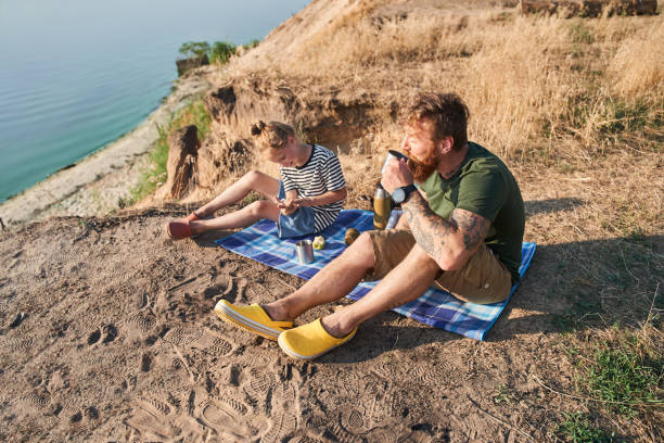 istock Two persons enjoying hot drinks while sitting at the nature 1341394421