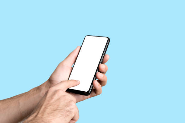 istock Empty smartphone in hand on colored blue banner background. Mockup phone with blank screen on minimal background 1341397016