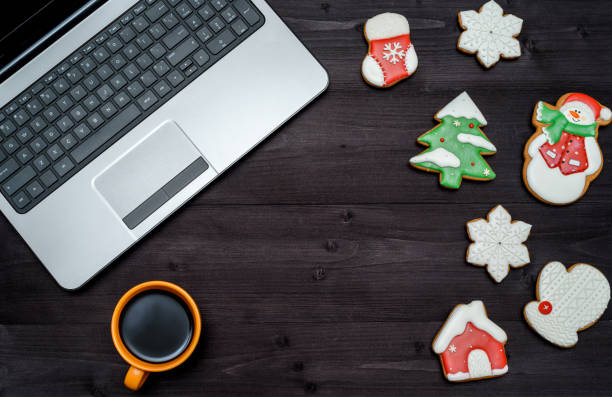 istock Laptop computer, cup of coffee and gingerbread cookies on dark wood background, copy space. Top view, flat lay. Christmas texture 1341399310