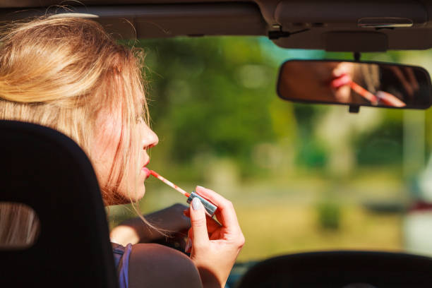 istock Girl apply make up while driving car. 1341401610