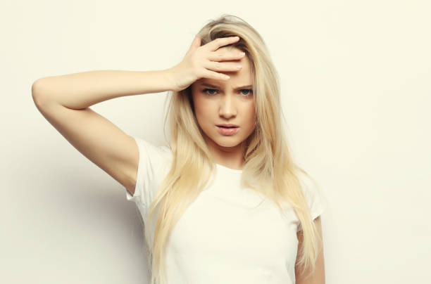istock Young woman has headache, over white background 1341402826