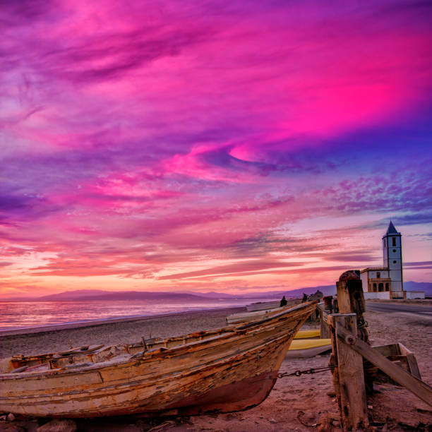 Cabo de Gata in Almeria at San Miguel Beach and Salinas church with stranded boats at sunset