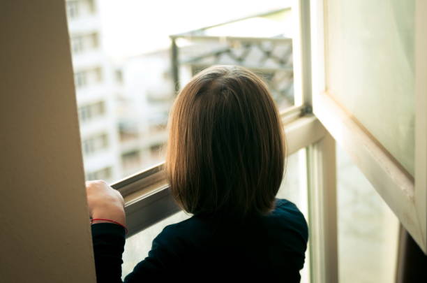 istock Little Girl Looking Out The Window 1341403488