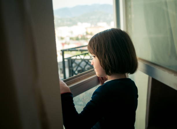 istock Little Girl Looking Out The Window 1341403522