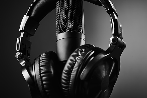 Studio microphone and headphones on the black background. Online podcast concept