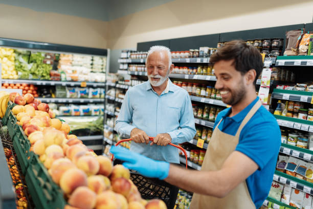 istock Employee in supermarket arranging fresh fruit 1341405995