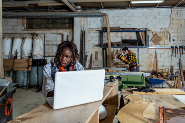 istock Young black woman using a laptop in a workshop 1341406749