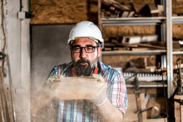 istock Mature Carpenter blowing off sawdust 1341406844
