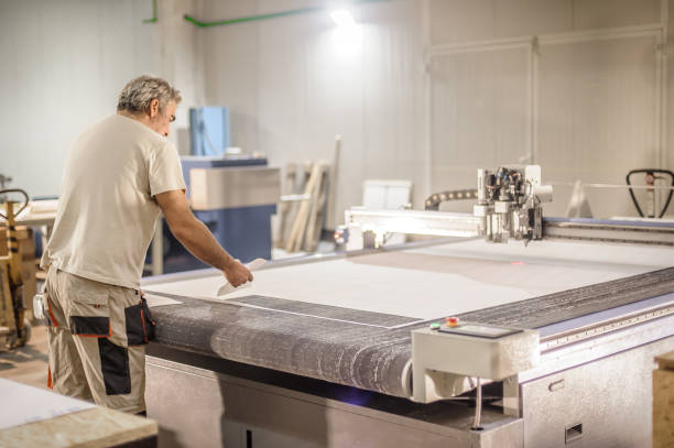 istock Technician works on CNC digital cutter machine for cutting textile 1341409023