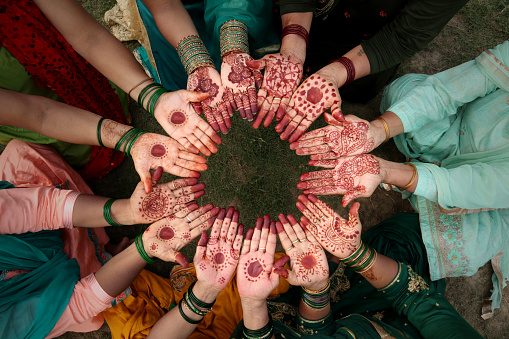 Group of Indian unrecognizable females showing henna hands on, Teej, Haryali Teej (Hartalika Teej) traditional festival. Teej is the generic name for a number of Hindu festivals that are celebrated by women. Haryali Teej and Hartalika Teej welcome the monsoon season and are celebrated primarily by girls and women, with songs, dancing and prayer rituals. The monsoon festivals of Teej are primarily dedicated to Parvati and her union with Shiva.