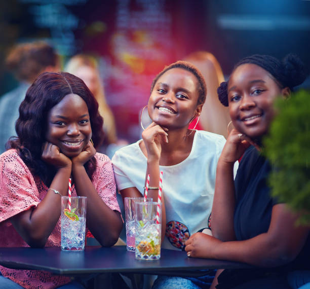 un grupo de amigos afroamericanos divirtiéndose en el restaurante de la calle, fiesta de verano - drinking straw drinking juice women fotografías e imágenes de stock