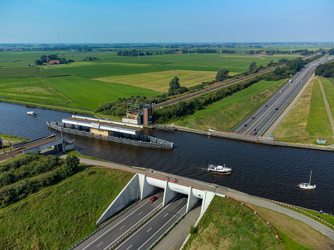 Aqeuduct Akwadukt Mid-Fryslân water bridge with recreational boats passing traffic on the highway below in near Grou in Friesland, The Netherlands during a beautiful summer day