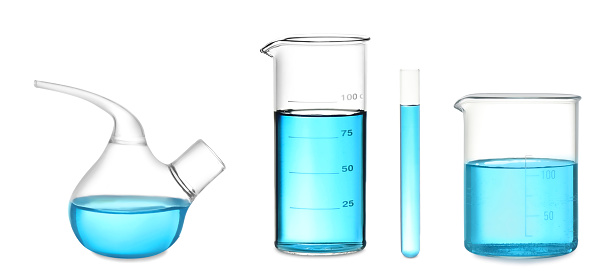Set of laboratory glassware with blue liquid on white background. Banner design