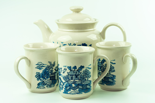 Three china-themed coffee cups and teapot. Porcelain or ceramic.