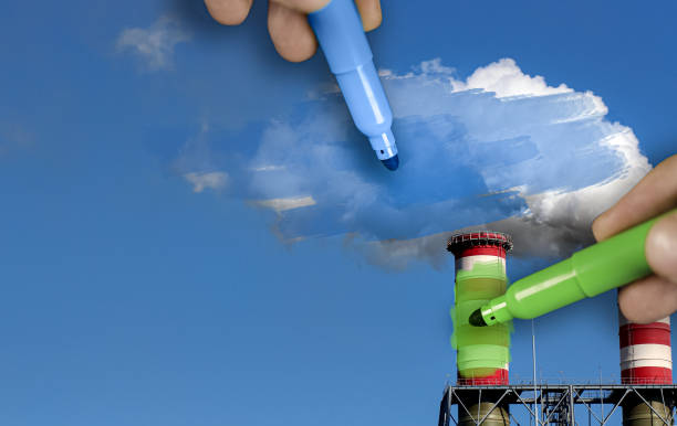 Hands painting blue and green pollution from a chimney stock photo