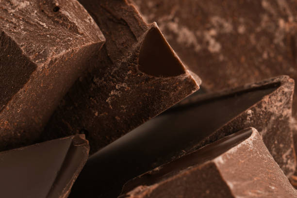 istock Pieces of dark chocolate as background, closeup 1341420096