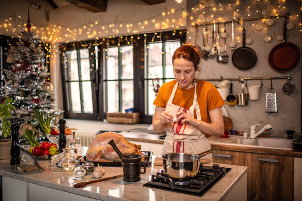 istock Young woman preparing a turkey for Christmas dinner 1341421841