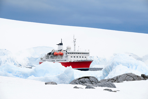 Expedition boat in Port Locroy surrounded by ice, Port Lockroy, Antarctica.