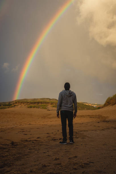 istock man from behind looking at the rainbow 1341424445