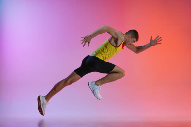 istock Young man, male athlete in motion isolated over gradient studio background. Running. Side view. Flyer 1341424581