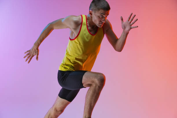 istock Cropped image of young professional male athlete isolated over gradient studio background. Marathon preparation 1341424589