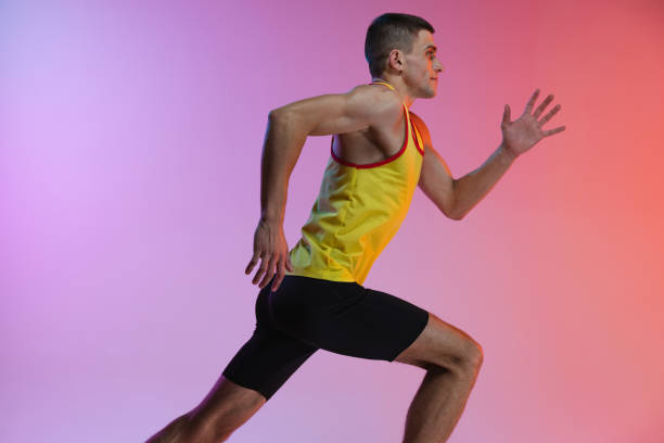 istock Cropped side view image of male athlete in motion isolated over gradient studio background. 1341424592