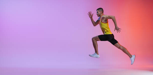 istock Young man, male athlete in motion isolated over gradient studio background. Running. Side view. Flyer 1341424595