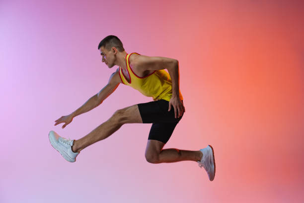 istock Young man, male athlete in motion isolated over gradient studio background. Side view 1341424603
