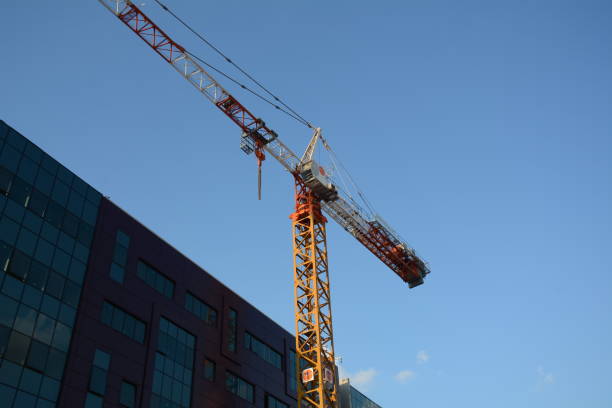 istock Tower crane working at construction site on blue sky background with white clouds. Construction process of the new residential buildings 1341427033
