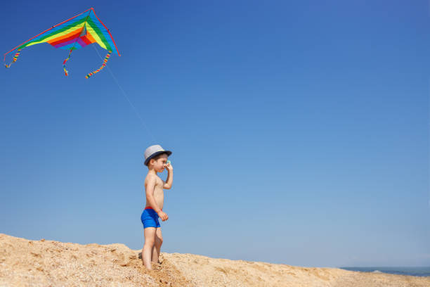 istock little boy with colorful kite on the beach 1341427400