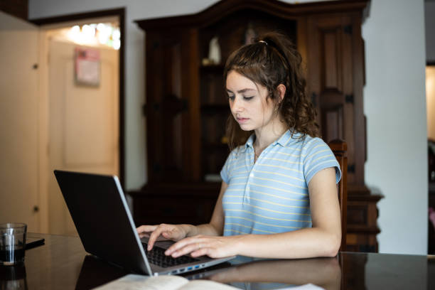 istock Young woman using laptop at home 1341427665