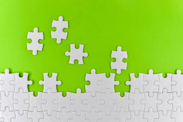 istock Unfinished white puzzle pieces on a green background 1341427889