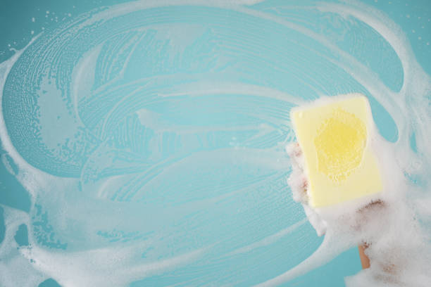 istock Man with rubber glove cleaning window. 1341427917