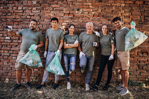 Portrait of group of volunteers after successful clean up of garbage in the park