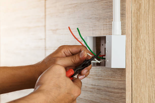 electrician is stripping electrical wires in a plastic box on a wooden wall . - electric plug outlet human hand electricity imagens e fotografias de stock