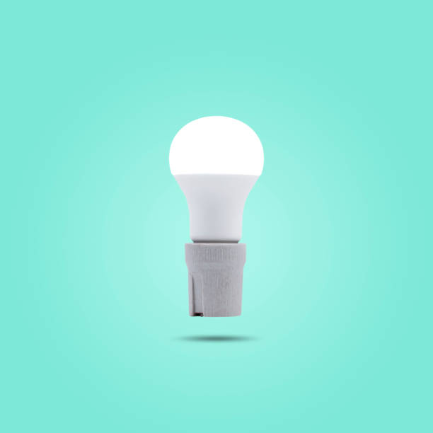 LED energy saving lamp 230v in a ceramic socket isolated on green pastel color background. stock photo
