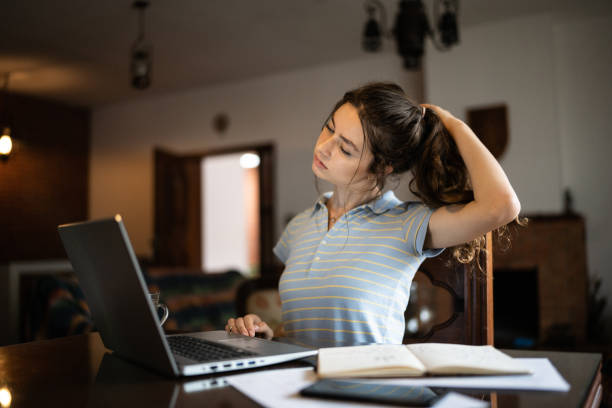 istock Tired young woman using laptop at home 1341429633