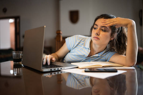 Tired young woman using laptop at home Tired young woman using laptop at home bad posture stock pictures, royalty-free photos & images