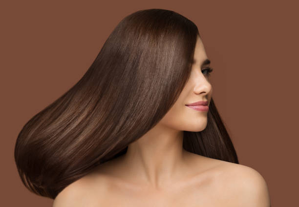 Hair Beauty Model. Brunette Woman with Long Straight Shiny Hairstyle over Dark Beige Background. Healthy Hair Care Hair Beauty Model. Brunette Woman with Long Straight Shiny Hairstyle over Dark Beige Background. Healthy Hair Care Salon Perfect Wig stock pictures, royalty-free photos & images