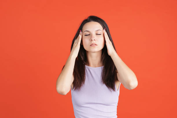 istock One beautiful caucasian girl posing isolated over red background. Having headache 1341433408