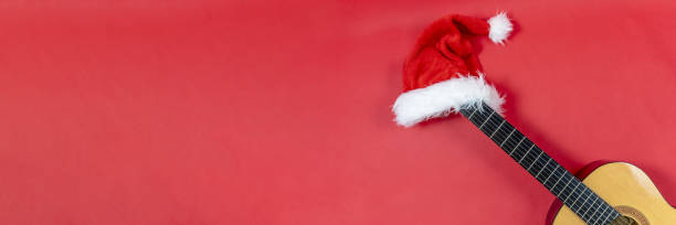 istock Banner with copy space Christmas guitar on a red background with Christmas Hat 1341433986