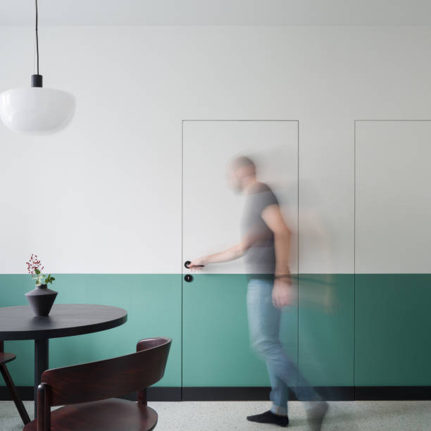 istock Man opening white and green doors in dining room 1341434118