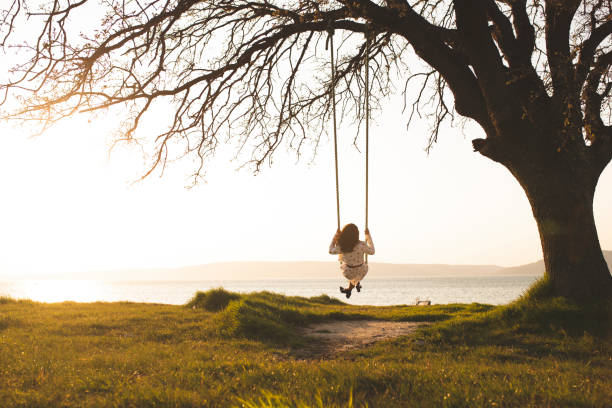 istock young woman on a swing at sunset 1341434726