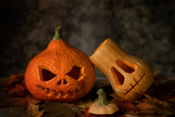istock Festive scary halloween pumpkins on leaves on a dark background 1341434991