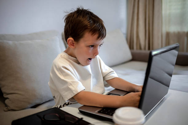 istock Child with laptop on a online class at home. 1341436864